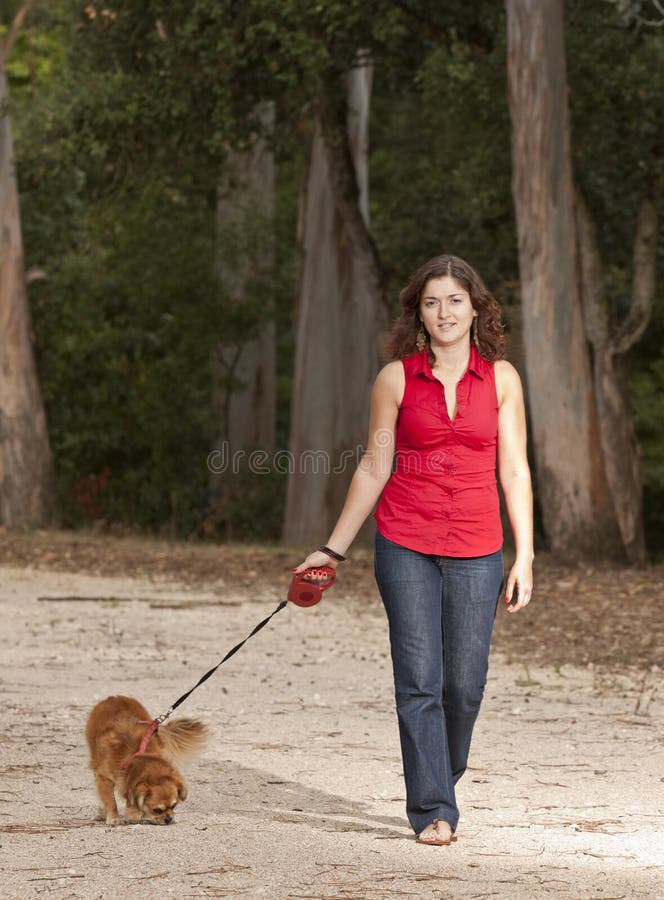 Girl with dog walking on the park.