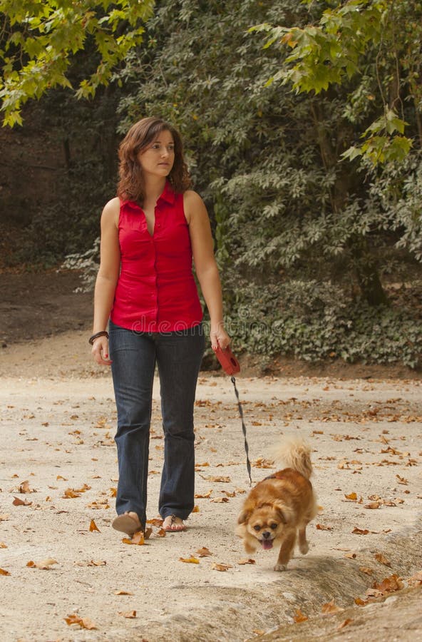 Girl with dog walking on the park.