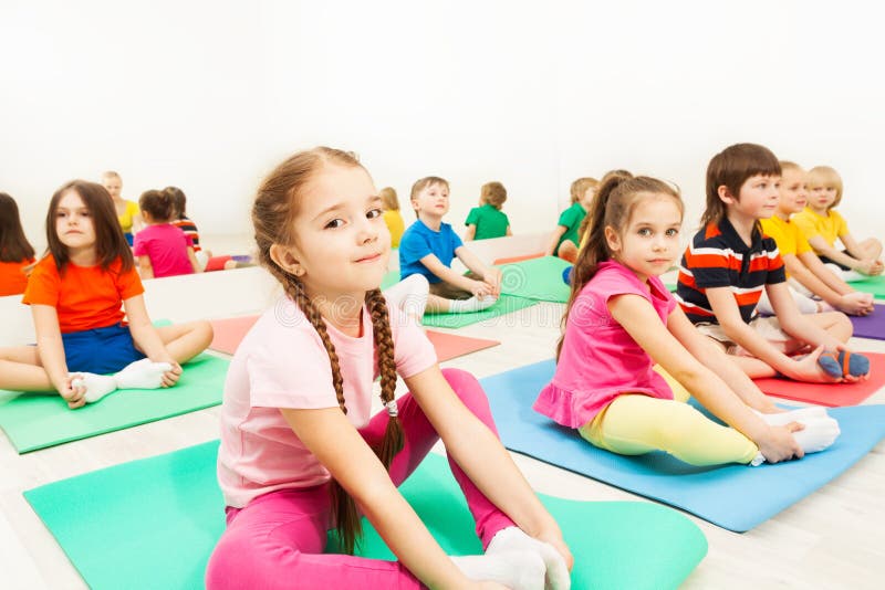 Girl doing butterfly stretch in gymnastic group