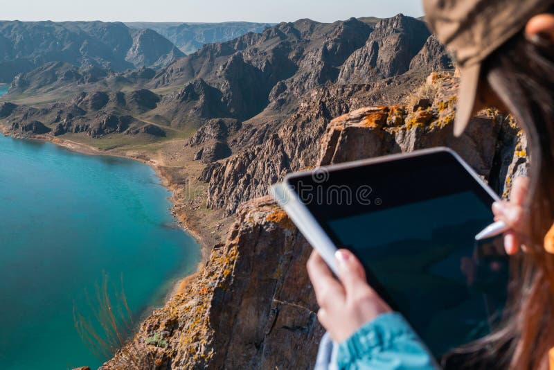 The girl draws the spring landscape of the river on the graphics tablet. Focused on the landscape royalty free stock photos The girl draws the spring landscape of the river on the graphics tablet. Focused on the landscape royalty free stock photos