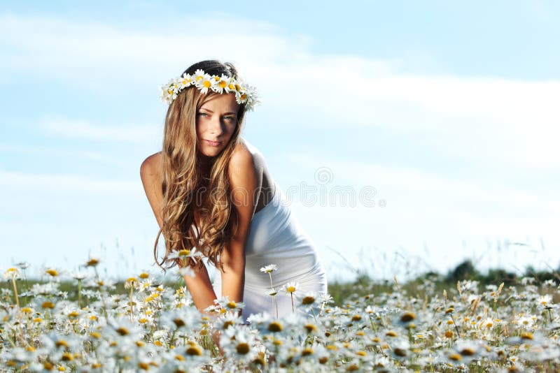 Girl in dress on the daisy flowers field