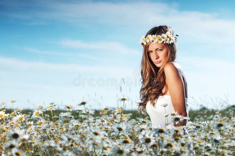 Girl in dress on the daisy flowers field