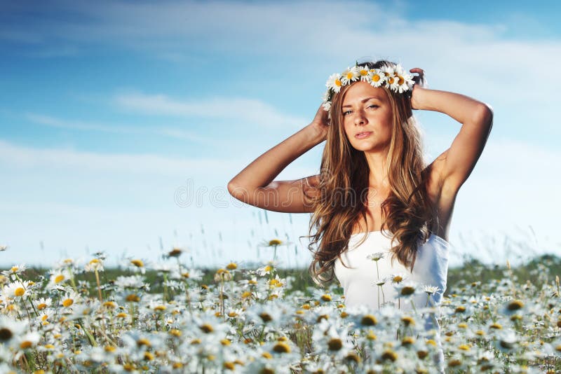 Girl in dress on the daisy flowers field