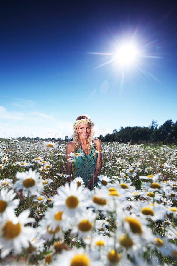 Girl in dress on the daisy flowers field