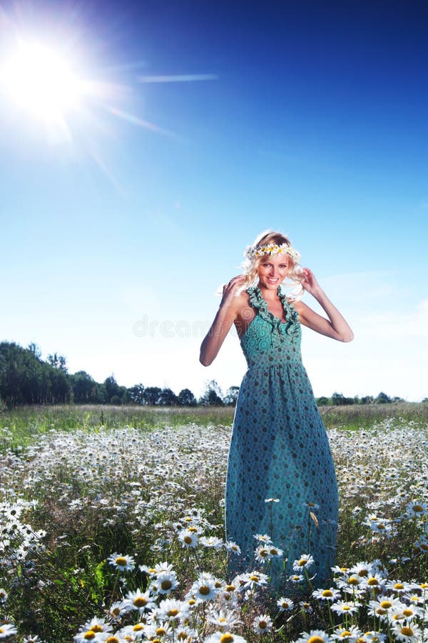 Girl in dress on the daisy flowers field