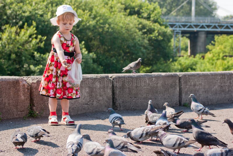 Girl in dress feeding pigeons