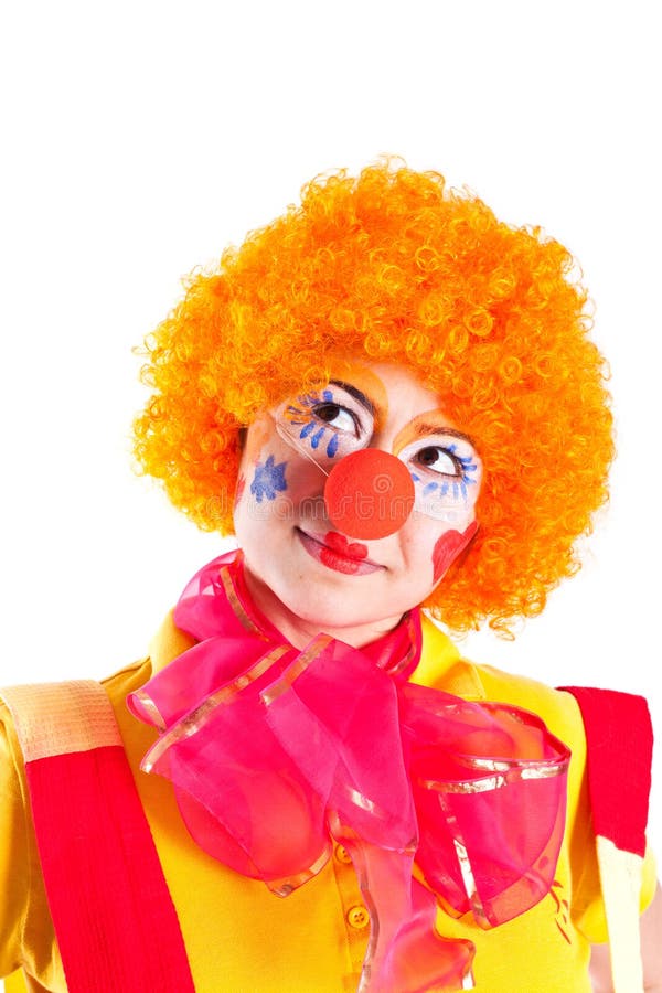 A girl dressed as a clown is looking up