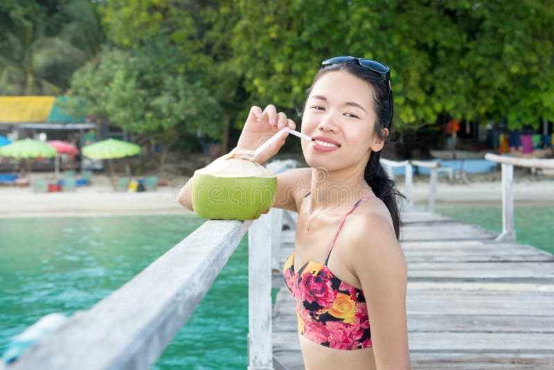 Girl drinking coconut water on a dock royalty free stock image Girl drinking coconut water on a dock royalty free stock image