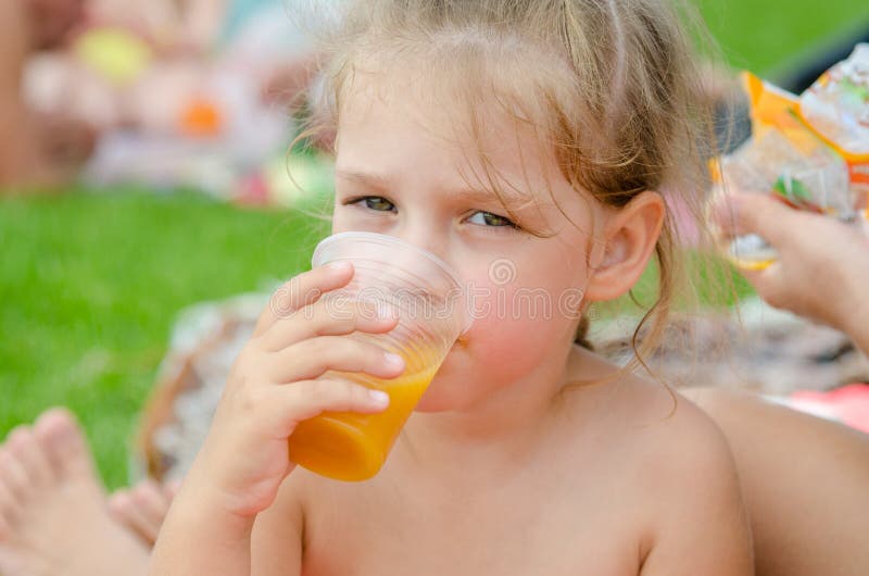 Girl Drinking Fruit Juice from Plastic Disposable Cup Stock Photo