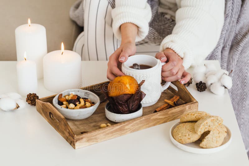 Girl drinks hot tea with cookies, nuts, cupcake