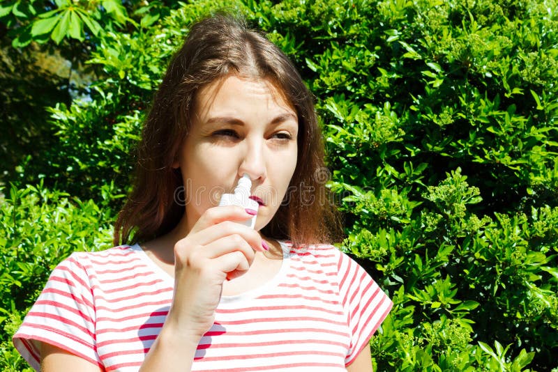 Girl drips blocked nose from allergy. Woman with Respiratory Spray for nose in Spring Blooming. Portrait of a woman having royalty free stock images Girl drips blocked nose from allergy. Woman with Respiratory Spray for nose in Spring Blooming. Portrait of a woman having royalty free stock images
