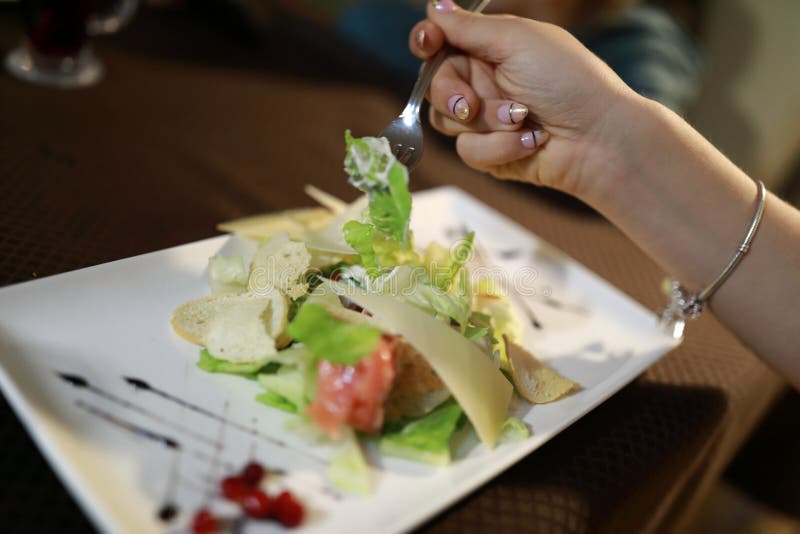 Girl eating Caesar salad stock photo. Image of fork 132280422