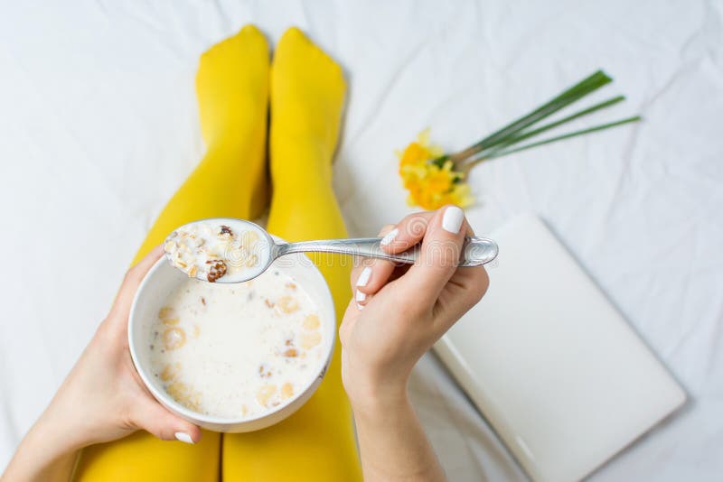 Girl eating cereals for breakfast in bed. Girl eating cereals for breakfast in bed