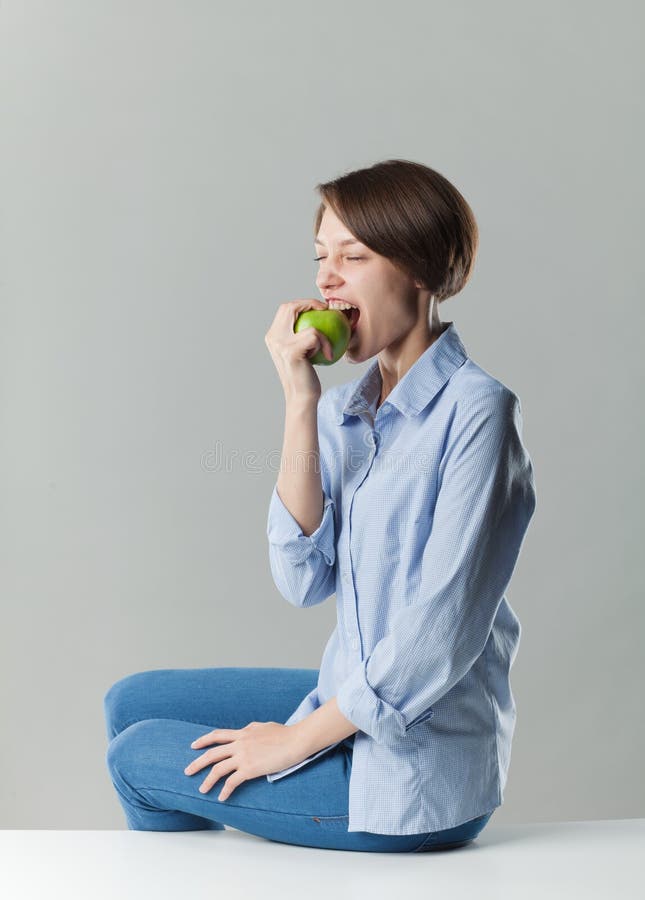 Girl eating a green apple stock images