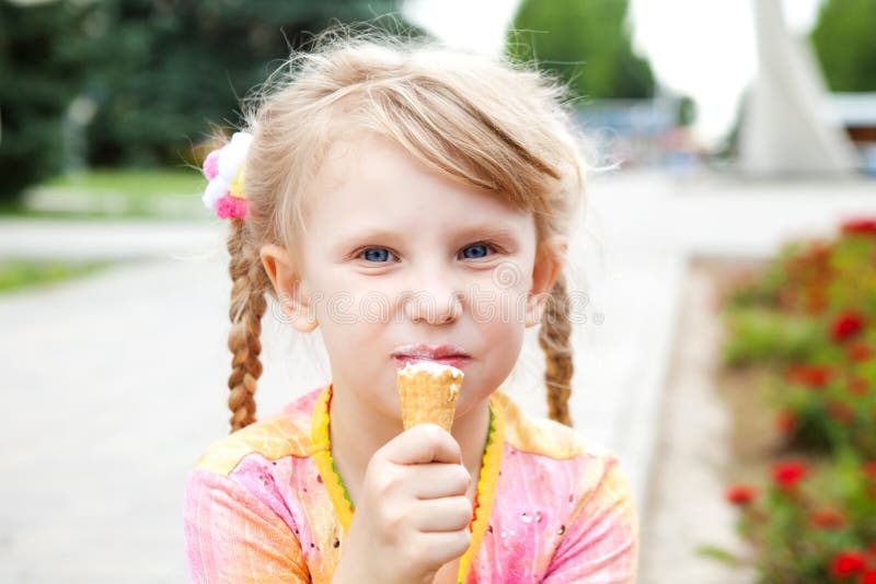 Маленькая девочка ест мороженое. Девочка ЕС мороженое эскимо. Ребенок ест эскимо. Девочка в платье ест мороженое. Девочка эскимо