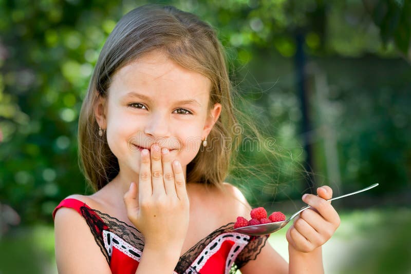 Girl eating raspberry