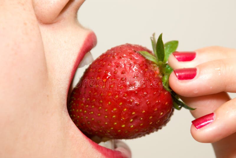 Girl eating strawberry closeup