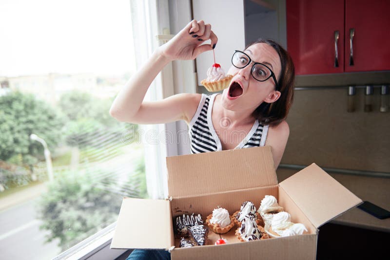 Girl eating tasty cakes, sitting by the window, sweet food and pleasure royalty free stock image Girl eating tasty cakes, sitting by the window, sweet food and pleasure royalty free stock image