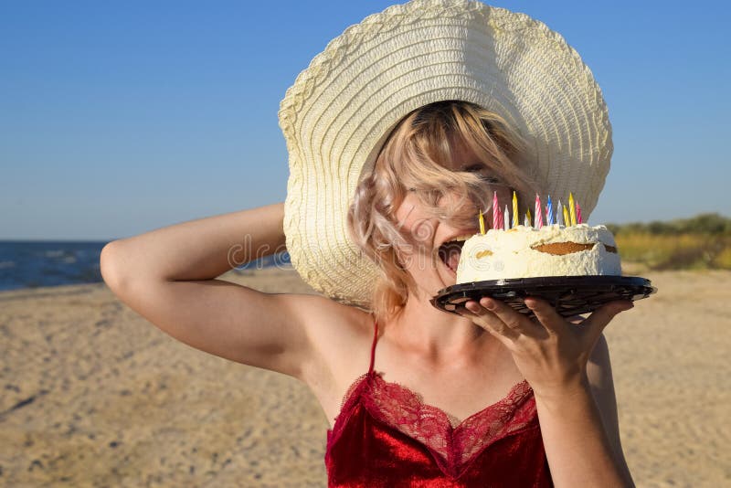 Girl Eats Cake on the Beach in a Hat. Stock Image Image of woman