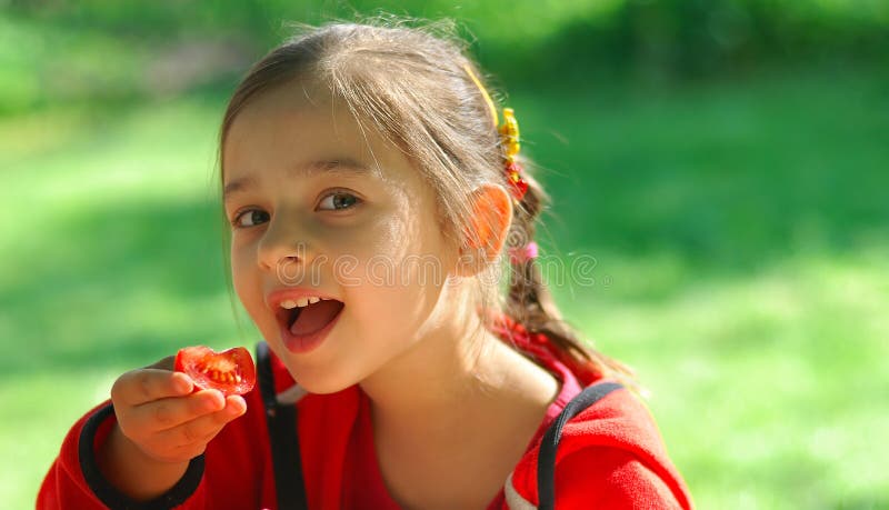 Girl eats tomato