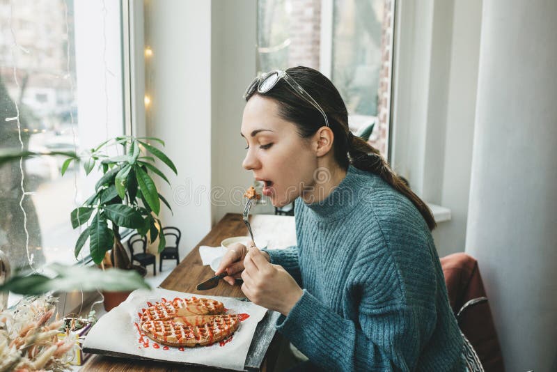 The girl eats a waffle stock images