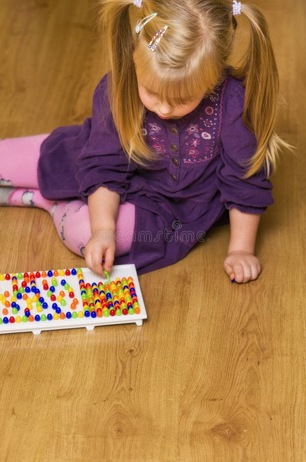 Girl with educational pin puzzle toy stock photos Girl with educational pin puzzle toy stock photos