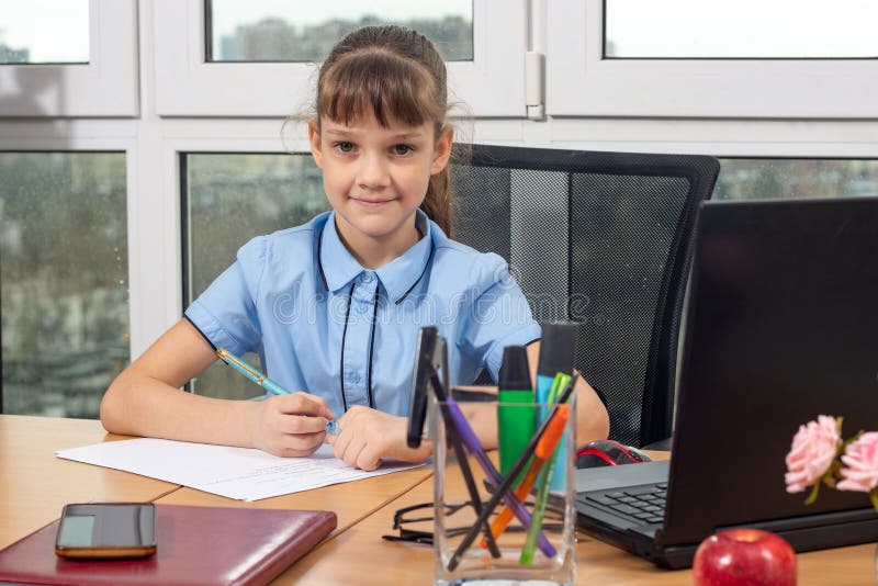 A girl of eight years old at the table in the office plays in the office employee royalty free stock photo A girl of eight years old at the table in the office plays in the office employee royalty free stock photo