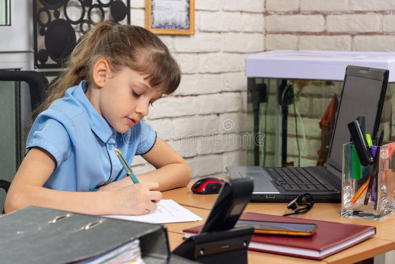 A girl of eight years old works at a table in an office stock photos A girl of eight years old works at a table in an office stock photos