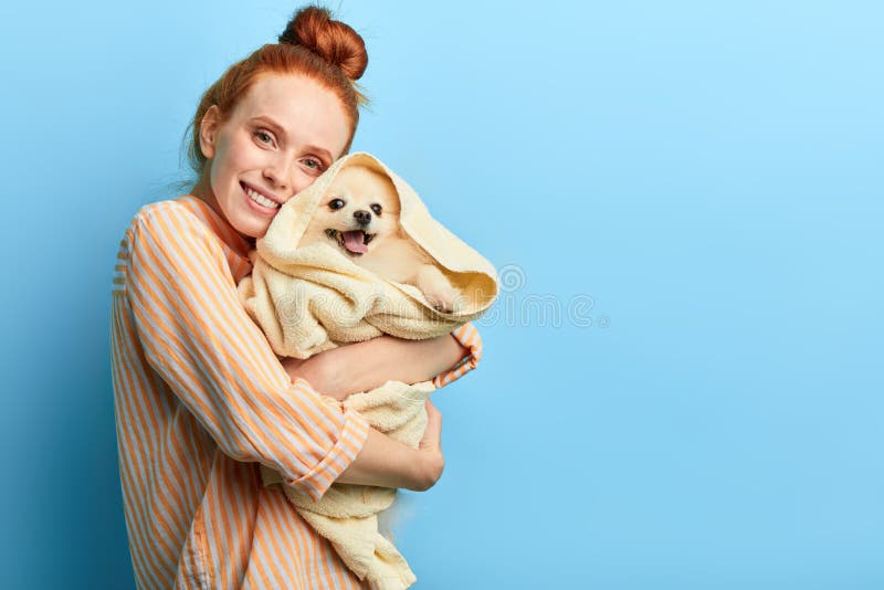 Girl embracing her dog, pet lover holding dog after taking a shower