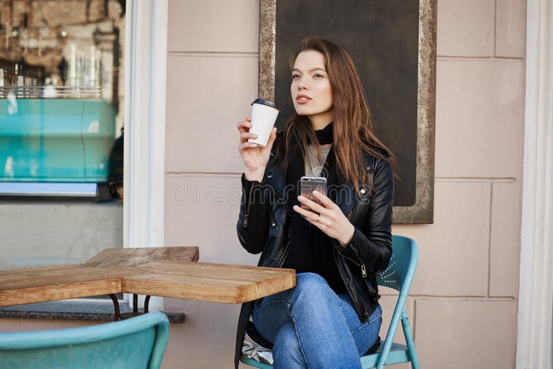 Girl enjoying warm and refreshing cup of coffee during lunch. Busy and successful woman sitting in cafe, drinking tea royalty free stock images Girl enjoying warm and refreshing cup of coffee during lunch. Busy and successful woman sitting in cafe, drinking tea royalty free stock images