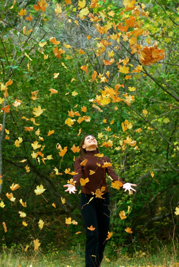 Girl in falling leafs stock image