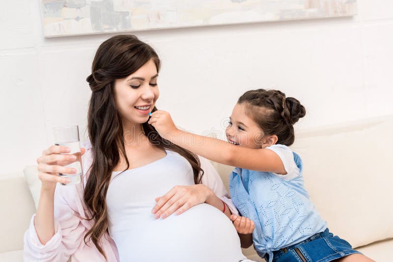 Girl feeding pill to mother stock photography Girl feeding pill to mother stock photography