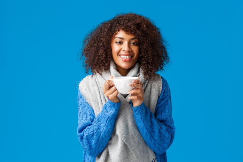 Girl feeling better after comming home and brewing delicious cup tea. Attractive smiling african-american happy woman