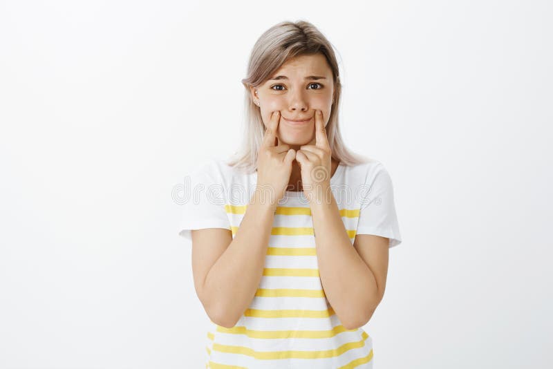 Girl feeling very lonely and upset, trying to keep smiling. Portrait of gloomy cute woman with fair hair, pulling smile royalty free stock photos Girl feeling very lonely and upset, trying to keep smiling. Portrait of gloomy cute woman with fair hair, pulling smile royalty free stock photos