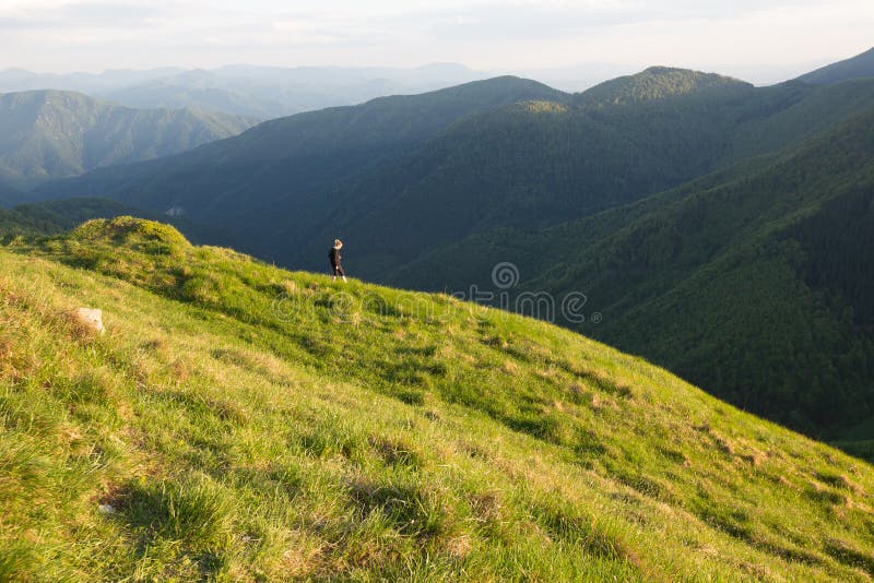 Girl female is looking on sunset in mountains and enjoy life, freedom