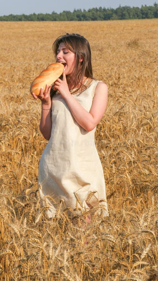 Girl in the Field Bites a Loaf of Bread Stock Photo Image of back