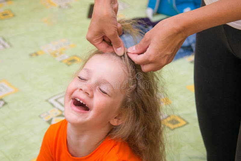 Girl of four years old sitting happily when she do her hair stock photography Girl of four years old sitting happily when she do her hair stock photography
