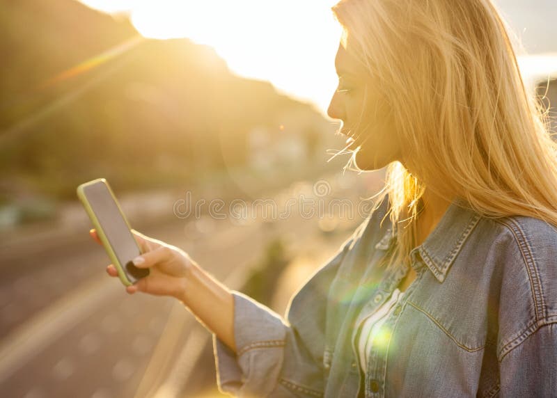 Girl freelancer at sunset speaks on the phone and works royalty free stock photo Girl freelancer at sunset speaks on the phone and works royalty free stock photo
