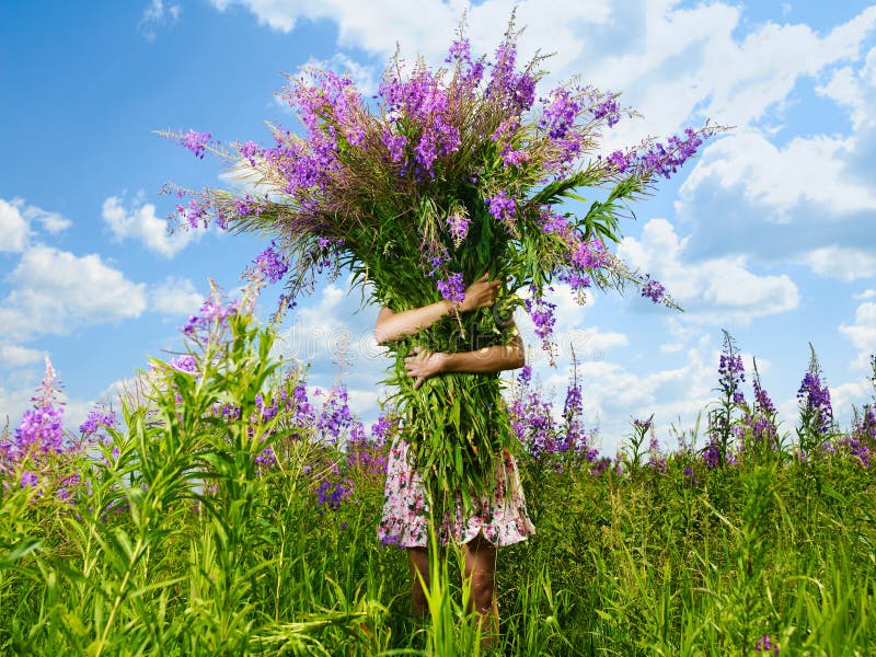 La fotografia di una ragazza con un enorme bouquet di fiori.