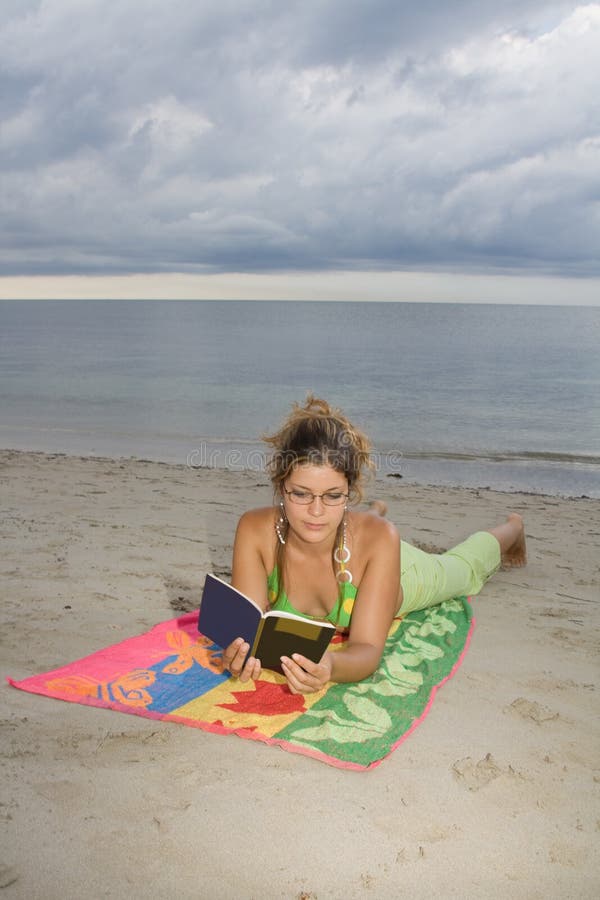 Girl with glasses reading a book (vert)