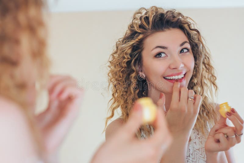 Girl glossing clear with the help of finger