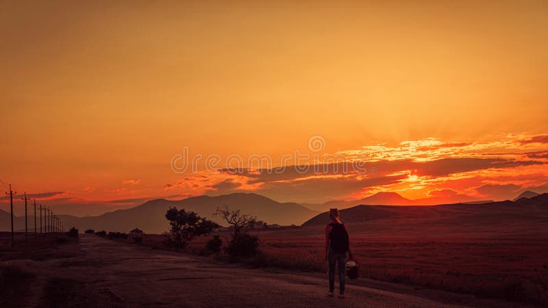 The girl goes on the road at sunset in the mountains royalty free stock photos The girl goes on the road at sunset in the mountains royalty free stock photos