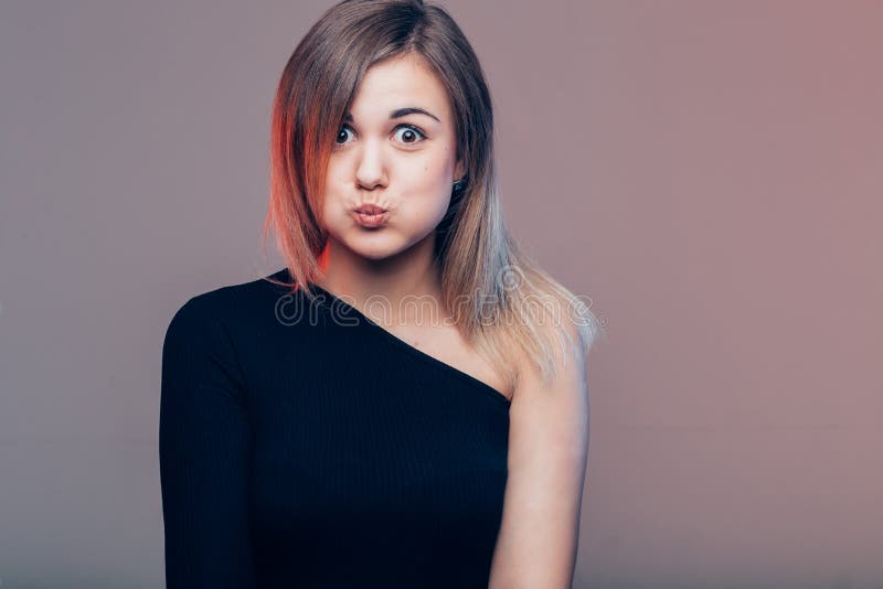 Girl going crazy in casual black clothes with red lips making a duck face royalty free stock images