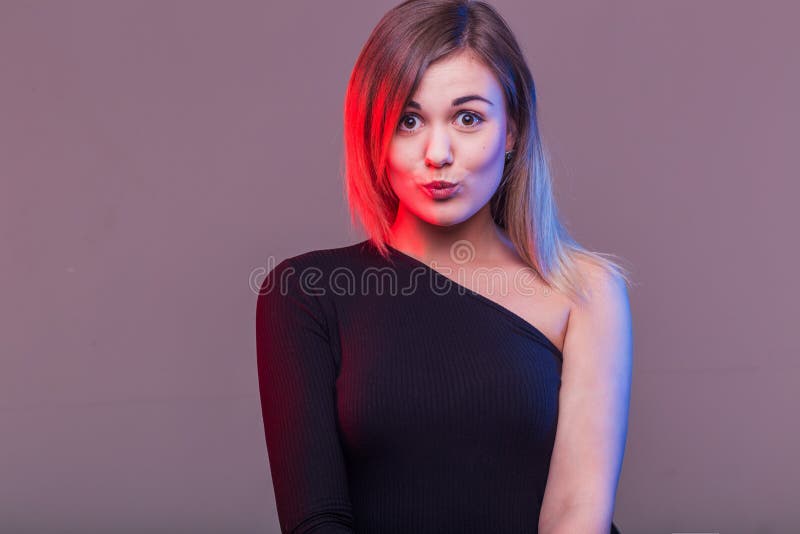 Girl going crazy in casual black clothes with red lips making a duck face stock images