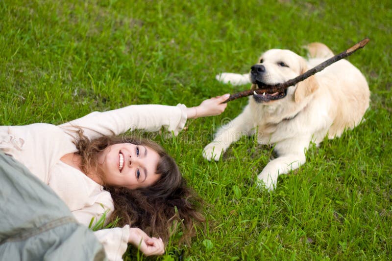 Girl on the grass and plays with the dog