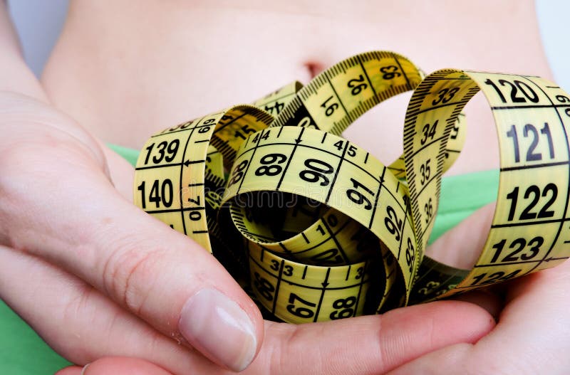 Woman measuring waist with measuring tape,Excess belly fat and