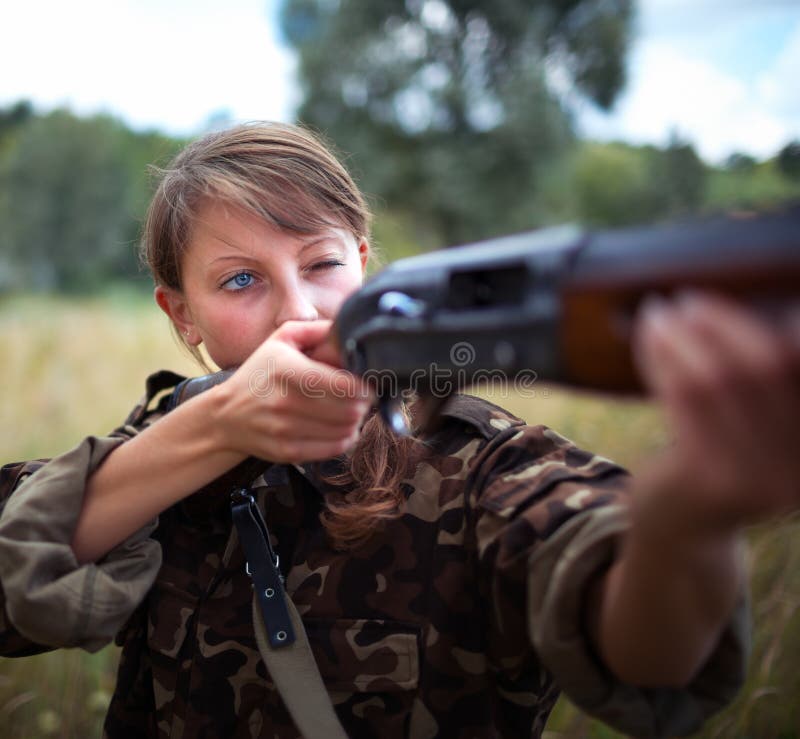 A young girl with a gun aiming at a target