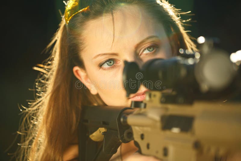 A young girl with a gun for trap shooting aiming at a target