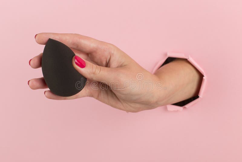 Cô gái cầm Beauty Blender trang điểm từ lỗ ở một nền hồng là một bức tranh tuyệt đẹp về nghệ thuật trang điểm. Với Beauty Blender, bạn có thể dễ dàng tạo ra một lớp trang điểm hoàn hảo và tự nhiên nhưng vẫn rất quyến rũ và cuốn hút. Hãy xem hình ảnh liên quan để cảm nhận sự tinh tế của sản phẩm này.