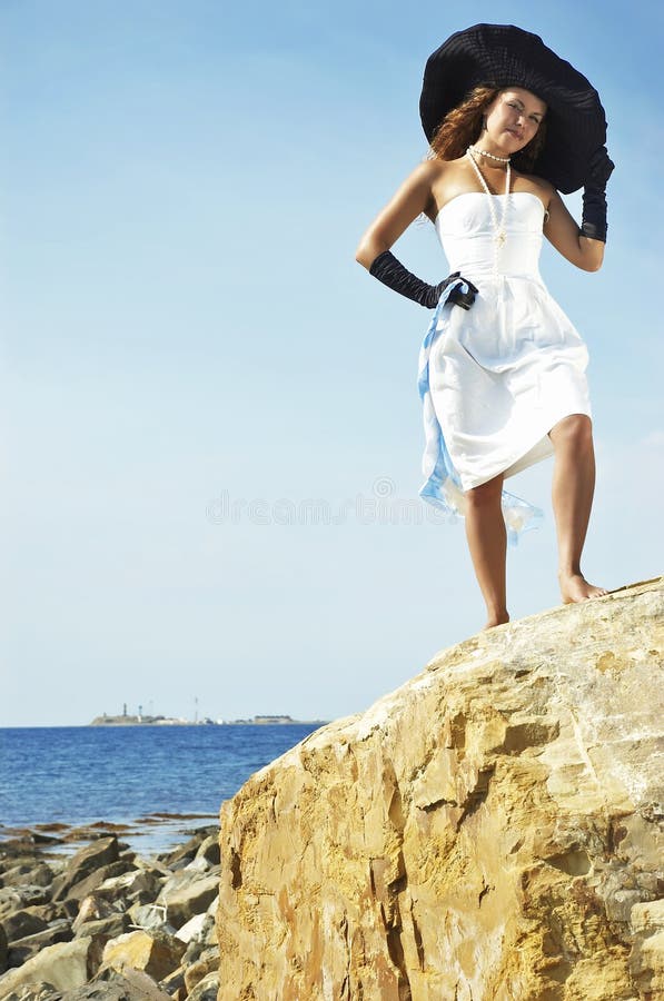 Girl in a hat on a coast of the sea